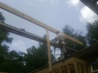 Carpenter setting a ridge beam over a new addition frame — Ice Dam Removal by Roofing Brothers in Sherrodsville