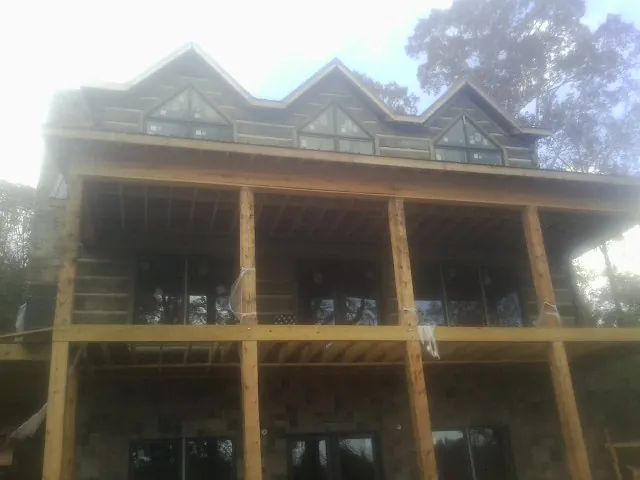 Dormers and porch framing on a large log home under construction — Roof Coating work by our crew in Sherrodsville