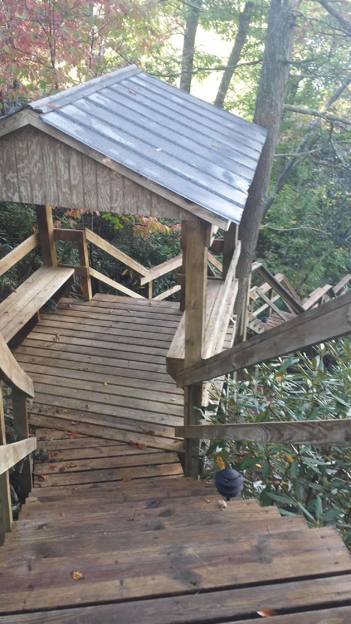 Metal roofed shelter over wooden steps on a wooded walkway — Skylight Repair & Installation work by our crew in Sherrodsville