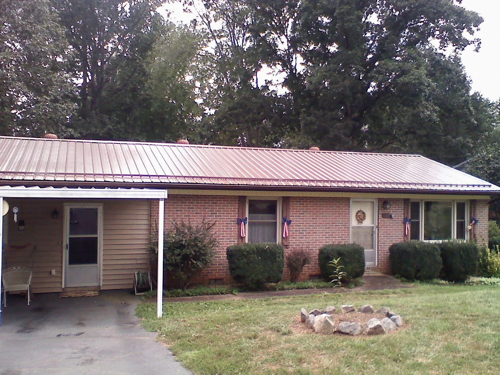 Bronze metal roof and carport on a brick ranch home — Roof Repair work by our crew in Sherrodsville