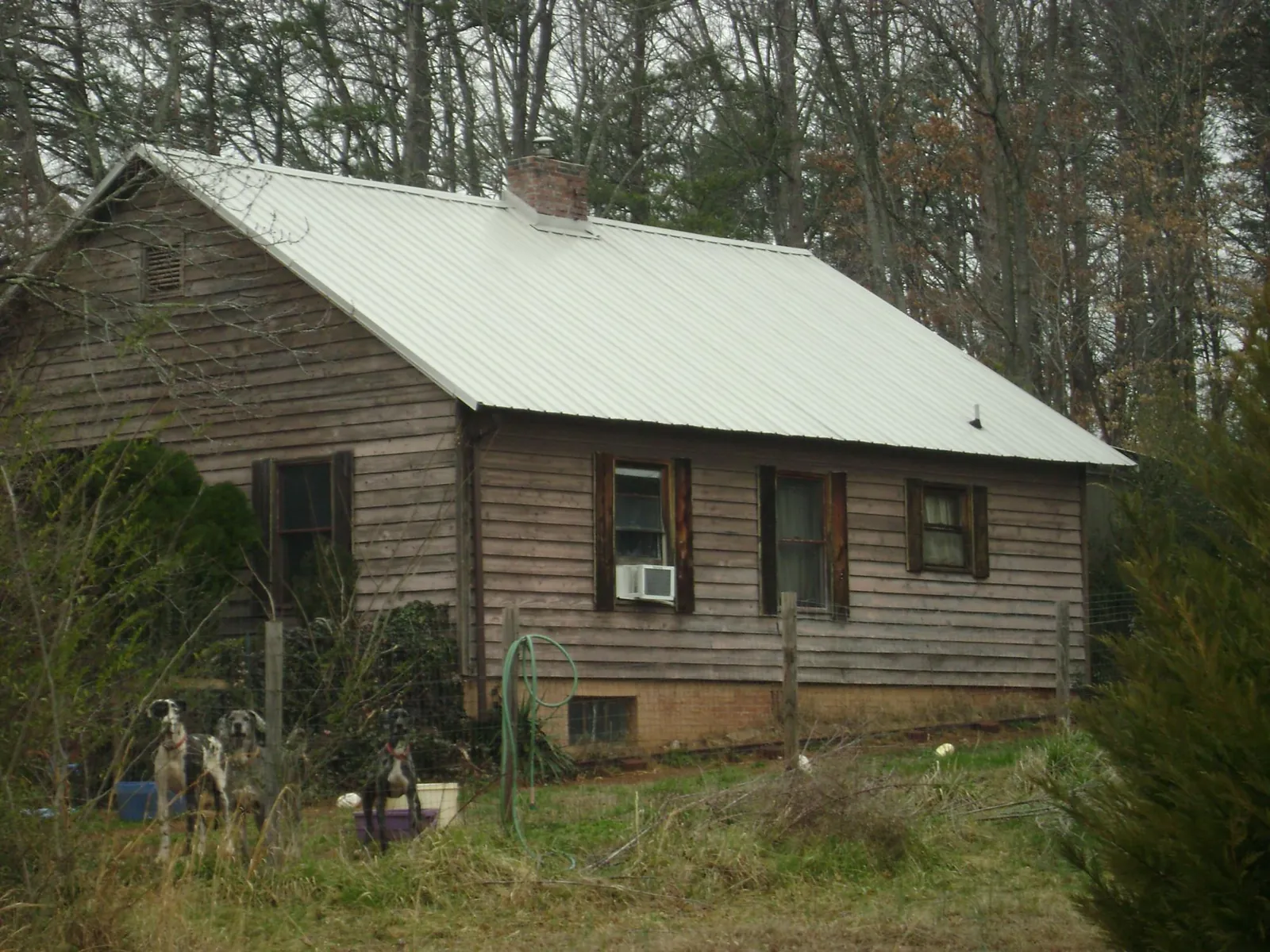White metal roof on an old wood sided farmhouse, from a Metal Roof Installation job in Sherrodsville